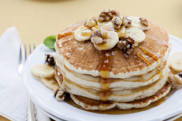 "Buttermilk pancakes topped with bananas, walnuts and maple syrup."